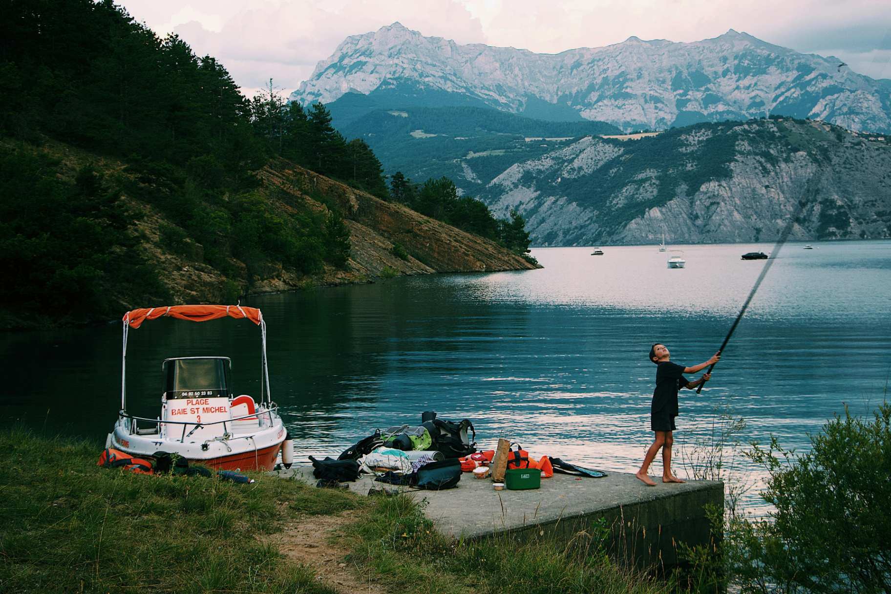 Pêche au coucher du soleil sur un lac de montagne