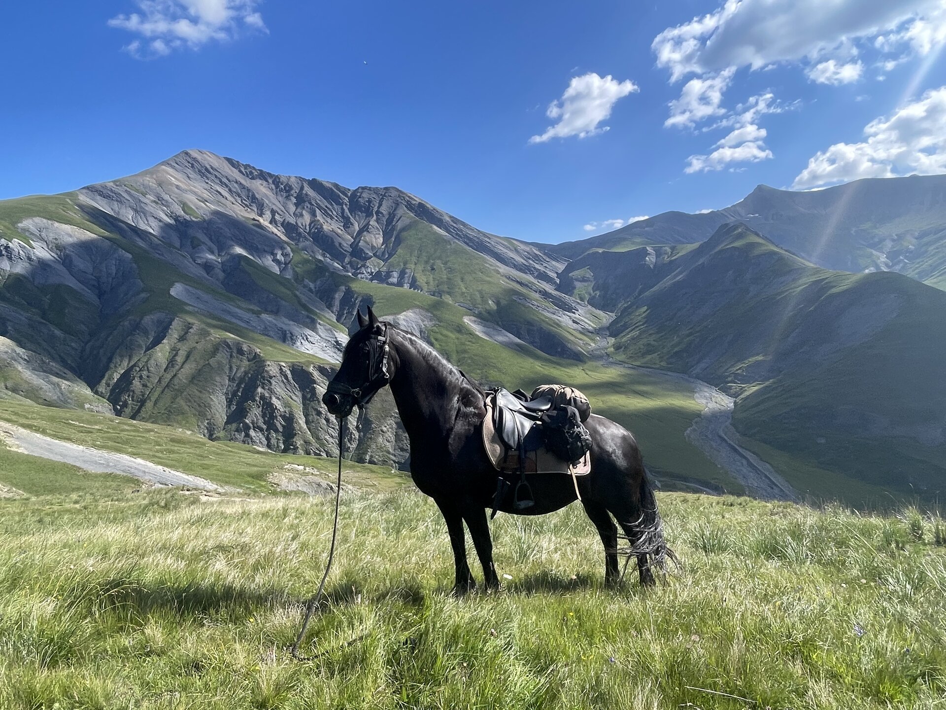 Cavaliers dans une vallée alpine au lever du soleil